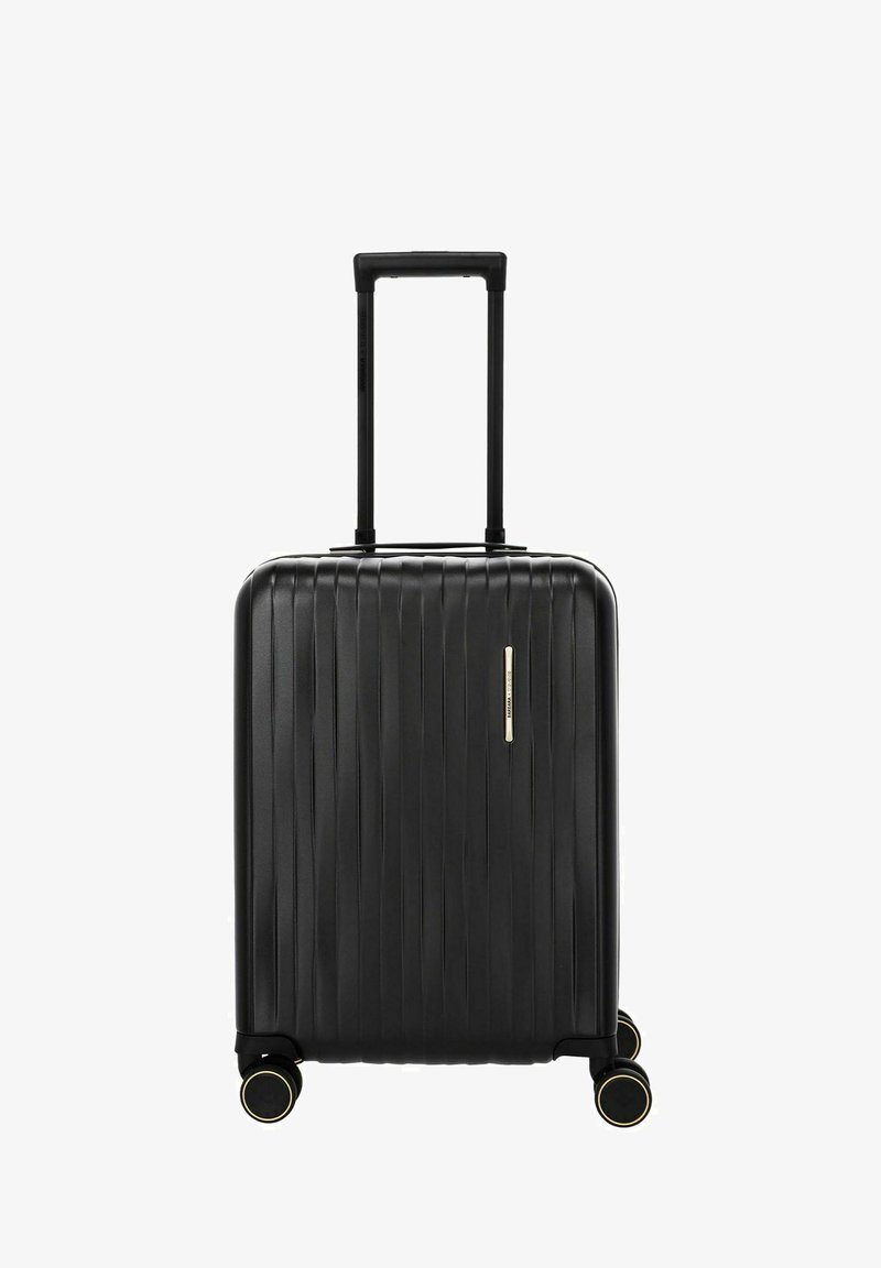 Maleta rígida negra con estrías verticales, cuatro ruedas dobles giratorias y un asa telescópica extendida.