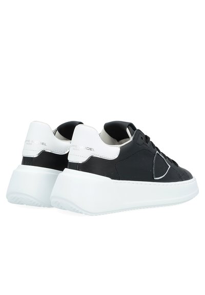 Black leather sneakers with white rubber sole, featuring a sleek design, smooth texture, and prominent logo on heel.
