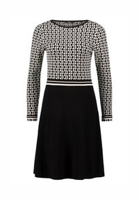 Langarm jurk met een zwart-witte geometrische patroon top en een effen zwarte rok, met een contrasterende tailleband detail.