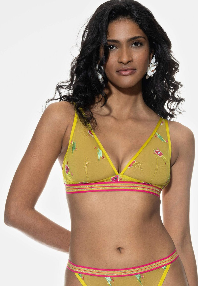Żółty siatkowy biustonosz braletka z kwiatowym haftem, trójkątnymi miseczkami i różowym paskiem w paski. Posiada żywe ozdoby i przezroczystą teksturę.