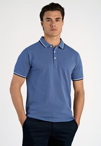 Koszulka polo z krótkim rękawem z niebieskiej bawełny z białym kołnierzykiem i krawędziami rękawów w paski, z trzyprzyciskowym zapięciem i detalem z logo.