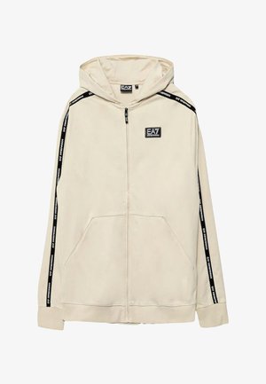 Felpa con zip beige chiaro, dotata di tasca frontale, strisce laterali nere e un patch del logo EA7 sul lato sinistro del petto. Tessuto morbido.
