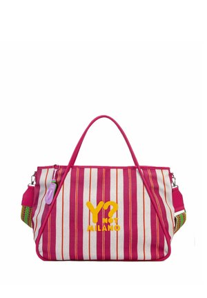 Borsa a mano larga a righe rosa e bianca con testo giallo "Y? Not Milano,", manici rosa e un portachiavi viola attaccato a un lato.