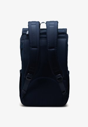 Czarny plecak z materiału, z wyściełanymi szelkami, prostokątny kształt i zasuwana kieszeń z boku. Gładka tekstura i minimalistyczny design.