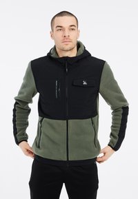 Fleece-Jacke mit Kapuze, schwarzem oberen Bereich und olivgrünen unteren Abschnitten. Verfügt über Reißverschlusstaschen und einen strukturierten Stoff.