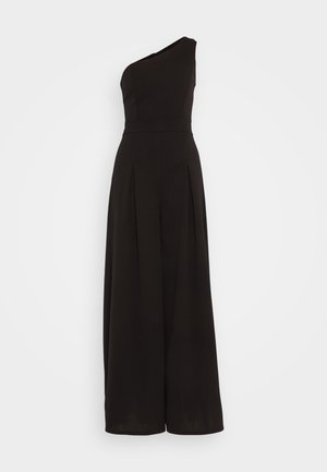 Mono negro de un solo hombro, con pliegues en la parte delantera, hecho de una tela suave, diseñado con una cintura ajustada y piernas anchas.