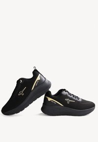 Black athletic shoes with a mesh upper, gold accents, padded collar, and textured outsole for grip. Features reinforced eyelets and branding.