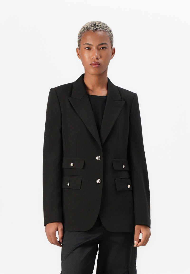 Svart blazer med snittet krage, dobbeltradet design og sølvfargede knappdetaljer. Har to frontlommer med klaffer. Skreddersydd passform.