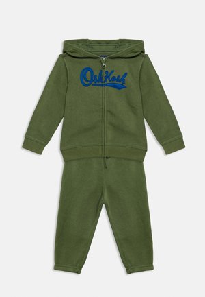 Ensemble deux pièces pour tout-petit vert olive avec un sweat à capuche zippé comportant un texte brodé bleu et un pantalon assorti.