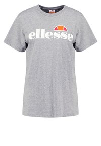 Šedé tričko s krátkým rukávem vyrobené z bavlny, s výrazným bílým logem "ellesse" a barevným slunečním grafickým motivem v oranžové a tmavě růžové barvě nad ním.