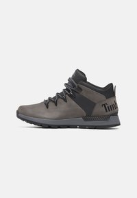 Botas de senderismo grises hechas de ante y material sintético, con un diseño de tobillo alto, acentos en negro y una suela de goma con un agarre texturizado.