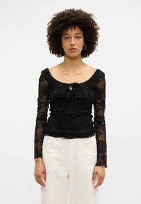 Μαύρο μακρυμάνικο μπλουζάκι με floral δαντέλα, λαιμόκοψη με άνοιγμα και κορδόνι μπροστά. Λείο υφή, εφαρμοστή σιλουέτα.