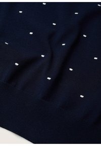 Pull en maille bleu marine avec de petits motifs rectangulaires blancs dispersés. Texture douce avec un ourlet côtelé en bas.