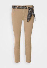 Pantalons skinny beige avec une ceinture en tissu noir à motifs. Comprend des poches cousues et un design ajusté, adapté à différentes occasions.