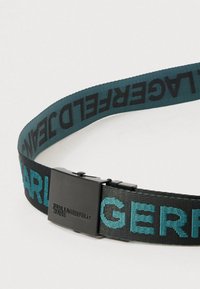 Čierny nylonový opasok s tyrkysovým vyšívaným nápisom "KARL LAGERFELD JEANS" a obdĺžnikovou čiernou kovovou prackou.