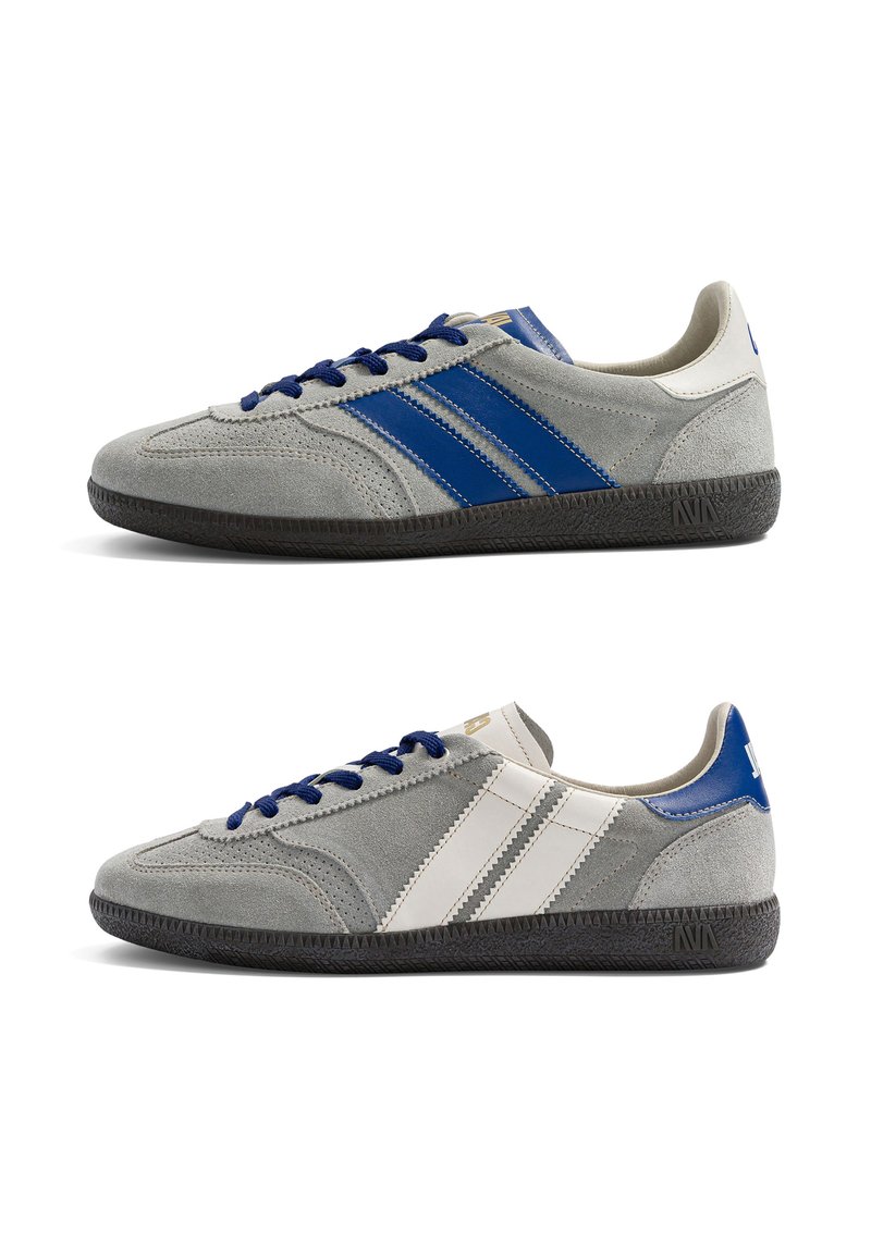 Deux baskets en daim gris avec des semelles noires ; la chaussure du dessus a des bandes et des lacets bleus, la chaussure du dessous a des bandes blanches et des accents bleus au talon.