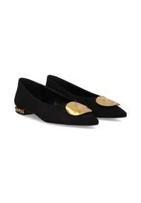 Bailarinas de ante negro con punta afilada, que presentan un gran detalle dorado en el empeine y un pequeño tacón metálico con tachuelas decorativas.