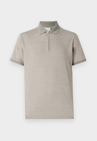 Polo shirt beige clair avec un col zippé, des manches courtes et des accents verts contrastés au niveau du col et des ourlets des manches.