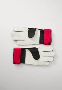 Gants de gardien de but avec une paume blanche, des doigts noirs et une sangle rouge au poignet. Prise texturée sur la paume, tissu lisse sur les doigts, fermeture ajustable.