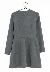 Robe grise à manches longues avec un tissu texturé, corsage ajusté et jupe évasée. Présente une fermeture éclair au dos et un col rond. Accrochée à un crochet.