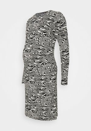 Vestido premamá de manga larga con estampado de cebra en blanco y negro y laterales fruncidos, diseñado para adaptarse a la silueta de una mujer embarazada.