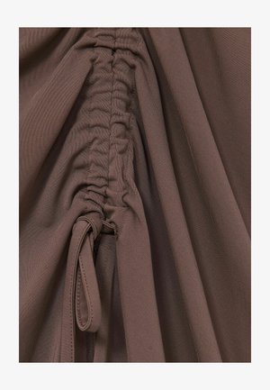 Brunt, tekstureret stof med sammenkrøllede sømme og en bundet detalje, der skaber en draperet effekt. Den glatte overflade forbedrer den visuelle dybde.