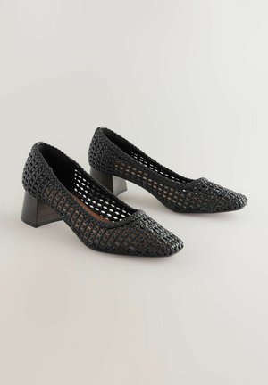 Schwarze gewebte Pumps mit offenem Mesh-Design, spitzem Schuhkopf und chunky Absatz. Hergestellt aus synthetischem Material mit strukturierter Oberfläche.
