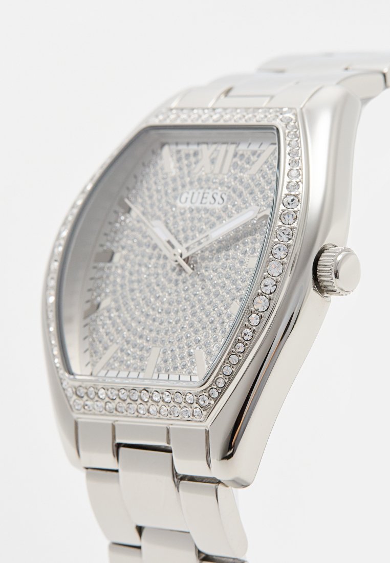 Reloj de acero inoxidable plateado con una esfera cuadrada, adornos de cristal, un dial texturizado y agujas metálicas. Cuenta con una correa de pulsera de eslabones.