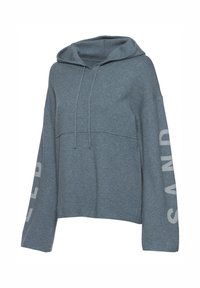 Hoodie cropped blu chiaro con coulisse, maniche lunghe e "SAND" stampato in bianco sulla manica destra. Tessuto morbido.