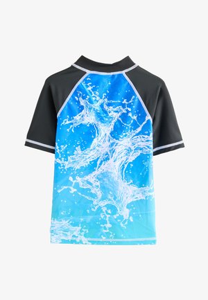 Majica za plavanje s kratkimi rokavi, ki ima spredaj modri vzorec v obliki razprška na prehodni podlagi, črne poudarke in visok ovratnik.