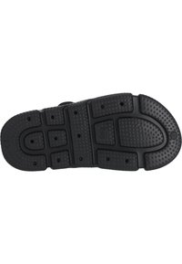 Schwarze Gummisohle mit einer strukturierten Oberfläche, die runde und rechteckige Muster aufweist, entworfen für Grip und Langlebigkeit.