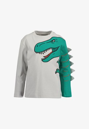 Camicia bianca a maniche lunghe per bambini con stampa di testa e braccio di dinosauro verde, caratterizzata da punte di tessuto lungo la manica destra.