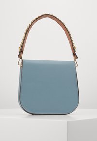 Light blue leather shoulder bag with a curved shape, a gold chain-accented handle, and smooth texture. Minimalist design with no visible logos.