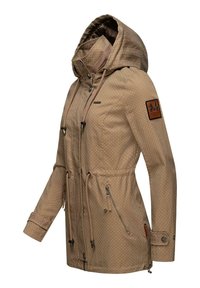 Veste imperméable beige avec motif à pois, taille ajustable par cordon, poche zippée et poignets boutonnés. Capuche attachée pour protection.
