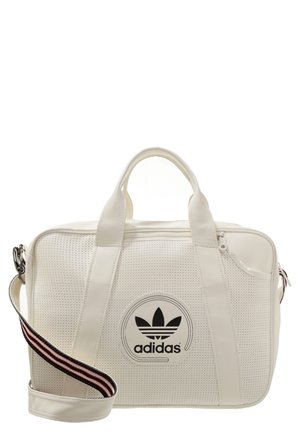 Witte Adidas duffel tas met geperforeerde textuur, dubbele handvatten, ritssluiting bovenaan en een afneembare gestreepte schouderriem.