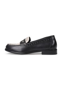 Mocasín de cuero negro con punta redondeada, que presenta una banda decorativa con adornos y acentos con tachuelas a lo largo de los lados. Tacón bajo y cuadrado.