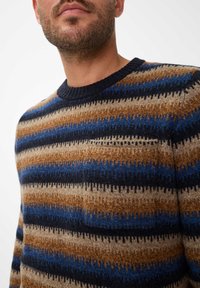 Gebreide trui met een ronde halslijn, horizontale strepen in bruin, blauw en crèmekleur, met een zachte textuur en variërende diktes.