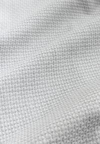 Light grey textured fabric with a diamond pattern, featuring a woven surface that creates a subtle, multi-dimensional effect.