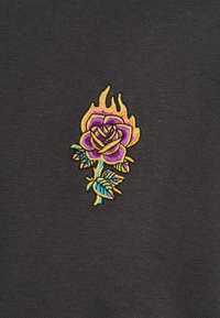 Tessuto grigio con un ricco design ricamato che presenta una rosa viola e fiamme gialle, accentuato da foglie blu.