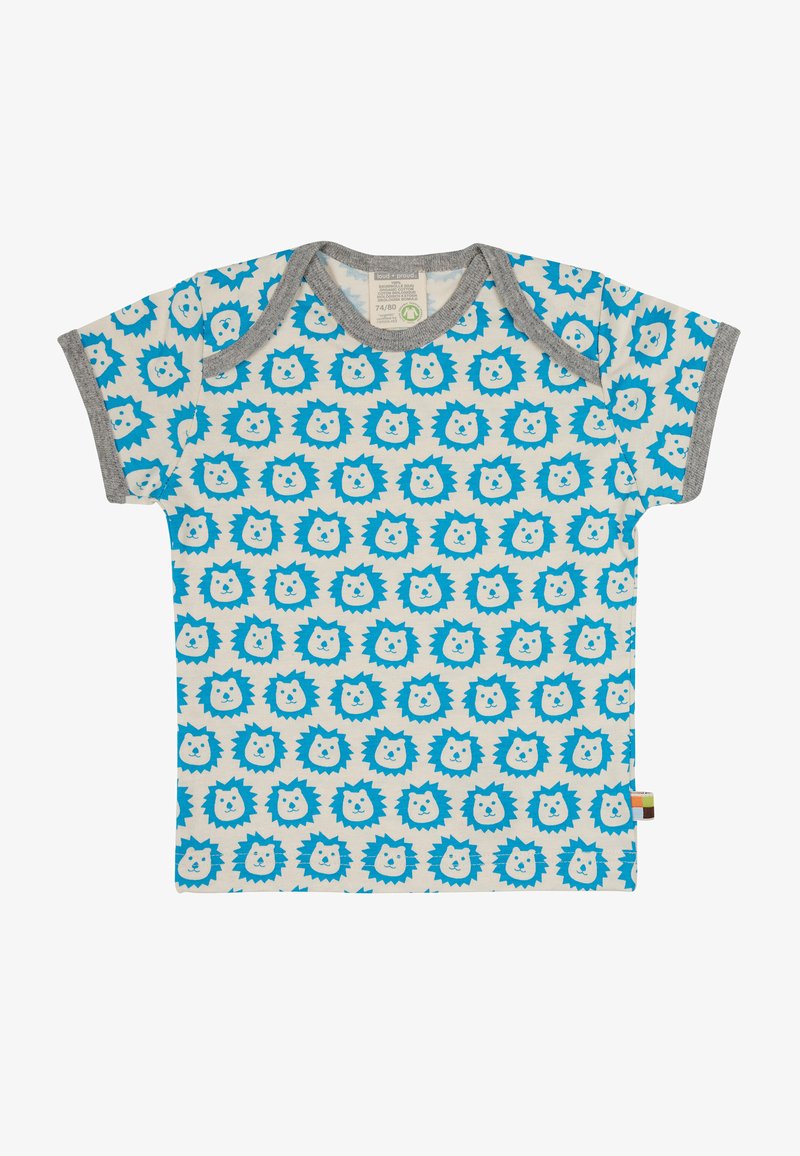 Blaues Löwenkopf-Muster auf cremefarbigem Baumwollstoff-T-Shirt mit grauem Saum; kurze Ärmel und Druckknopfverschluss an der Schulter für einfaches Anziehen.