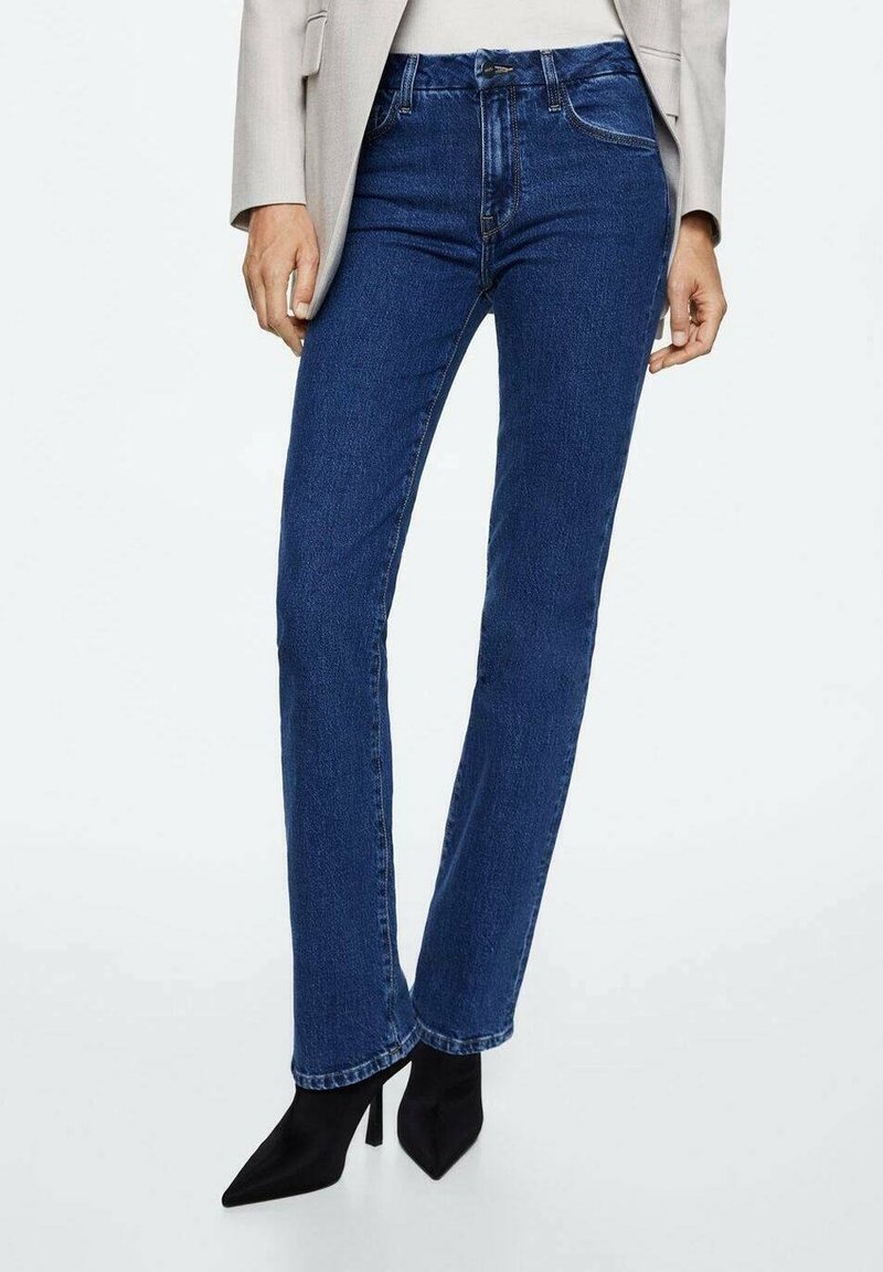 Jeans rectos azules con un diseño clásico de cinco bolsillos, confeccionados en tela de mezclilla, combinados con tacones negros de punta afilada.