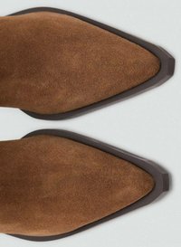 Brune ruskinds ankelstøvler med spids tå, der har en kontrasterende mørkebrun gummisål og en glat tekstur.