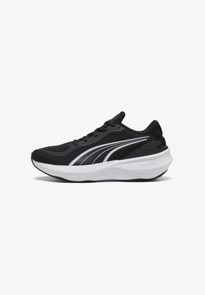 Chaussure de sport noire avec tige en mesh, semelle en caoutchouc et accents blancs. Elle possède un épais intercalaire en mousse et un design aérodynamique.