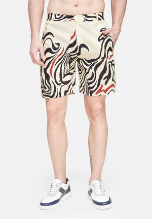 Beige Shorts mit einem schwarz-roten abstrakten Wellenmuster. Hergestellt aus leichtem Stoff mit einem Knopfverschluss und seitlichen Taschen.