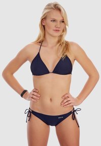Bikini triangle bleu marine en tissu lisse, avec des liens ajustables et un logo sur le côté du bas de bikini.