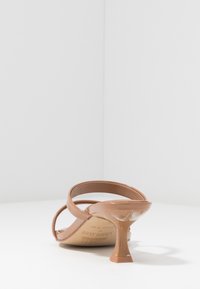 Bruna klacksandaler med en glänsande finish, som har två breda remmar och en smal, unik timeglas-klack för extra stil.