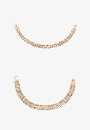 Due braccialetti d'oro con motivi di diamanti rettangolari e quadrati, con dettagli elaborati simili a perline lungo i bordi.