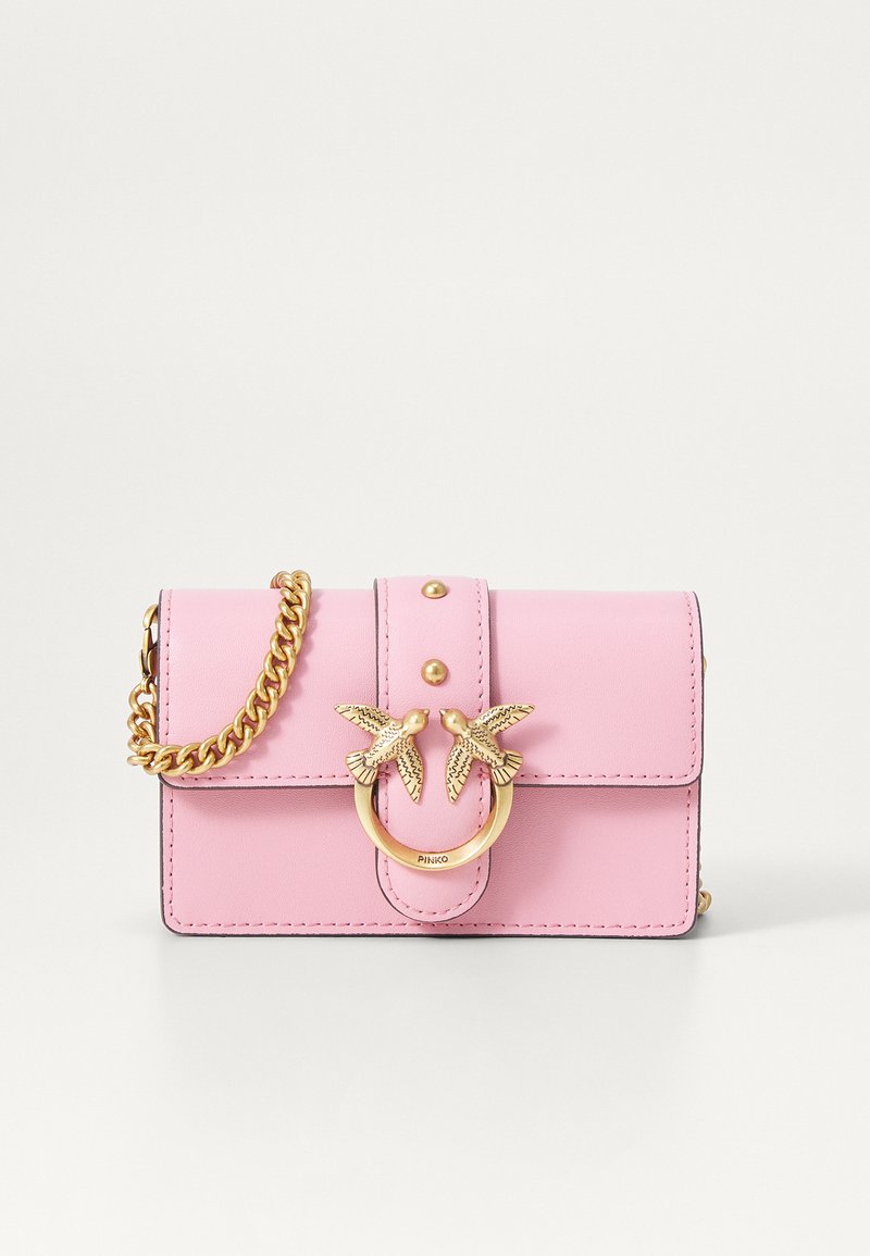 Ροζ δερμάτινη τσάντα χεριού με χρυσή αλυσίδα και χρυσό κούμπωμα σε σχήμα πουλιού στην μπροστινή κάλυψη.