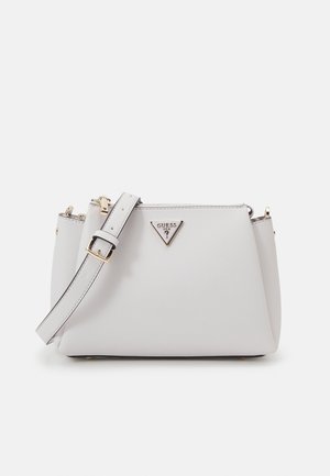 Weiße Leder-Schultertasche mit verstellbarem Riemen, goldenen Schnallen und dreieckigem Guess-Logo in der Mitte vorne.