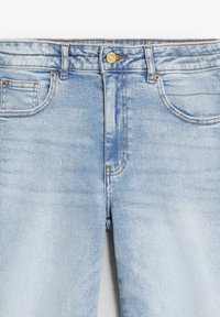 Jeans in denim azzurro chiaro con tasche anteriori, passanti per cintura e bottone metallico di chiusura in vita, mostrati frontalmente.